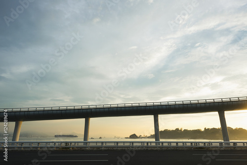 Highway from Xiamen city, China at sunset, with Gulangyu island in the background; Xiamen, China photo