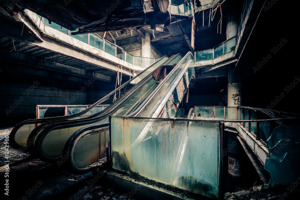 Fototapeta premium Dramatic view of damaged escalators in abandoned building. Apocalyptic and evil concept