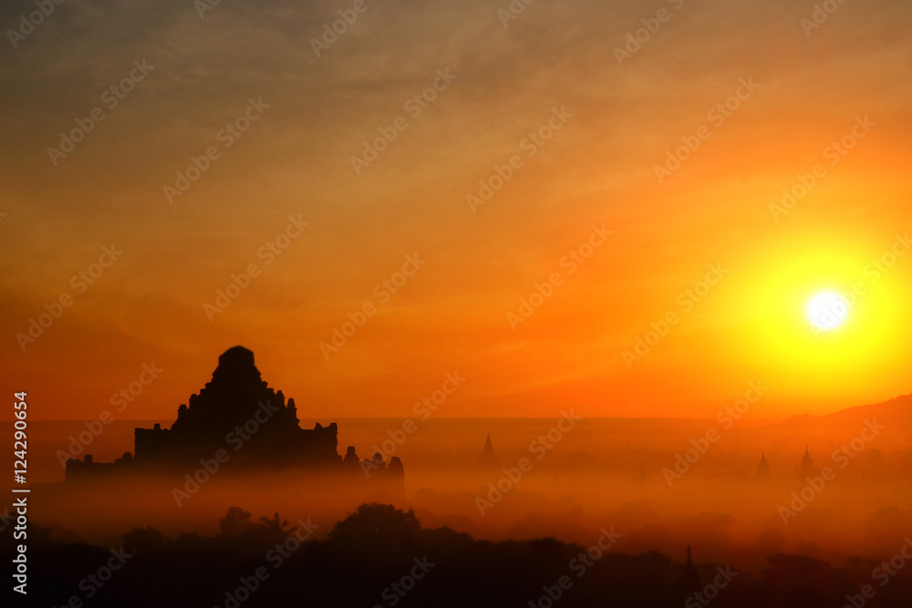 Tilt Shift blur effect. Amazing misty sunrise colors and silhouette of ancient Dhammayan Gyi Pagoda. Architecture of ancient Buddhist Temples at Bagan Kingdom. Myanmar (Burma) travel destinations