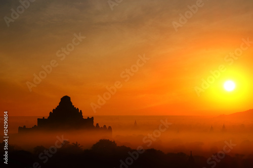 Tilt Shift blur effect. Amazing misty sunrise colors and silhouette of ancient Dhammayan Gyi Pagoda. Architecture of ancient Buddhist Temples at Bagan Kingdom. Myanmar (Burma) travel destinations
