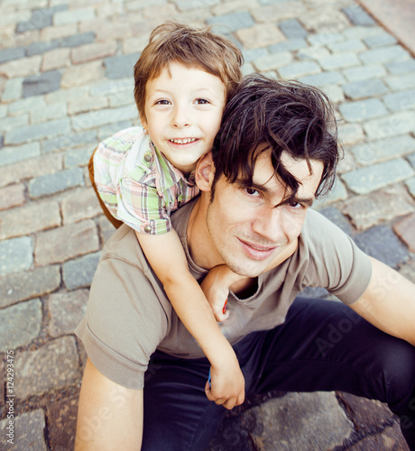 little cute son with modern mature hipster father in city happy smiling hugging, lifestyle people concept photo