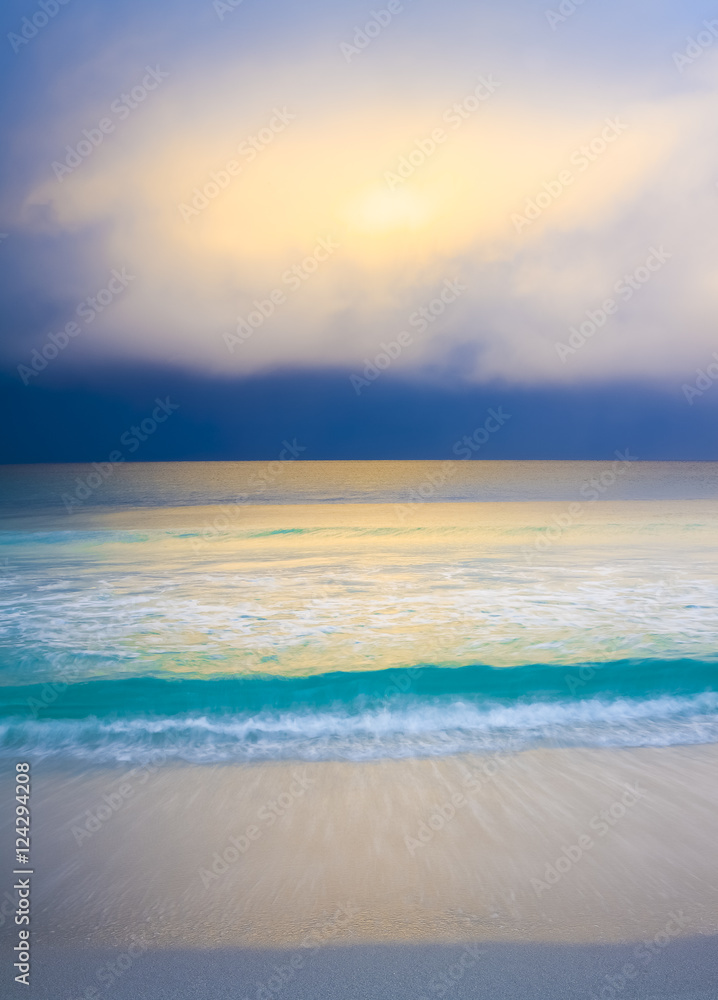 SOFT LIGHT WITH STORM ON BEACH. A lovely white sandy beach with turquoise water and colourful clouds.