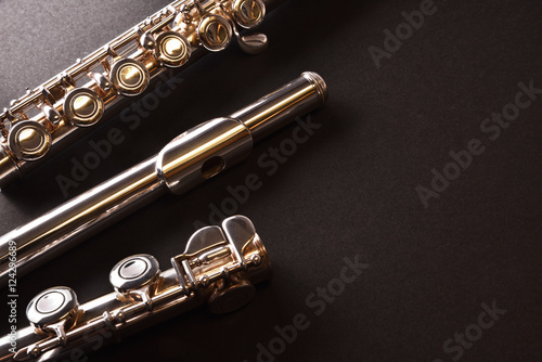 Fotografija Detail of tansverse flute disassembled three parts on black tabl