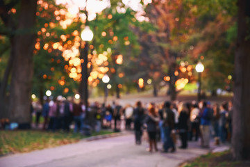 blurred background a crowd of people. a lot of people in the evening in the autumn park. concert, meeting, protest action. blurred motion