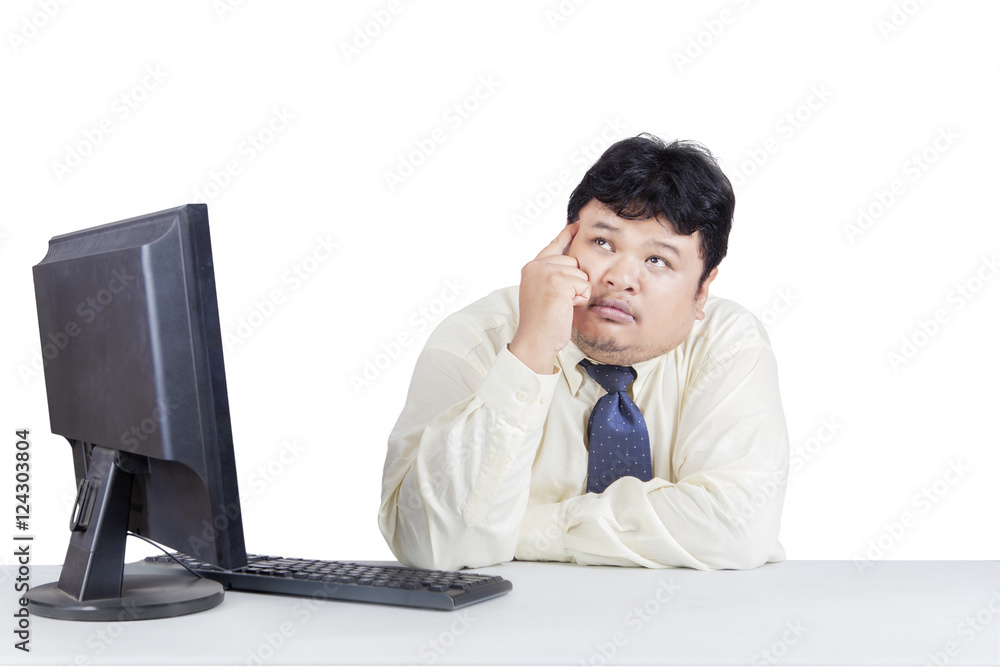 Pensive overweight businessman working with computer Pensive overweight businessman working with computer