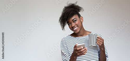 afro american woman with striped t-shirt and striped cup of caff © Myvisuals