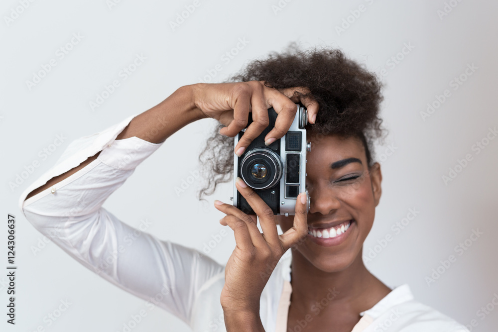 Afro american woman taking a picture with a vintage camera Afro american woman taking a picture with a vintage camera
