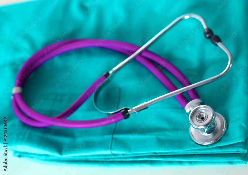 stethoscope shaping heart and clipboard on medical uniform, closeup stethoscope shaping heart and clipboard on medical uniform, closeup