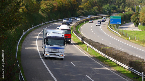 Trucks rolling in highway traffic from above and with blank road direction signs