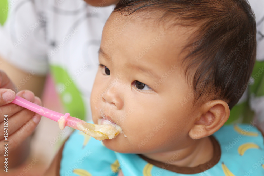 Asian baby boy to eating food in concept of health foods and nut Asian baby boy to eating food in concept of health foods and nut