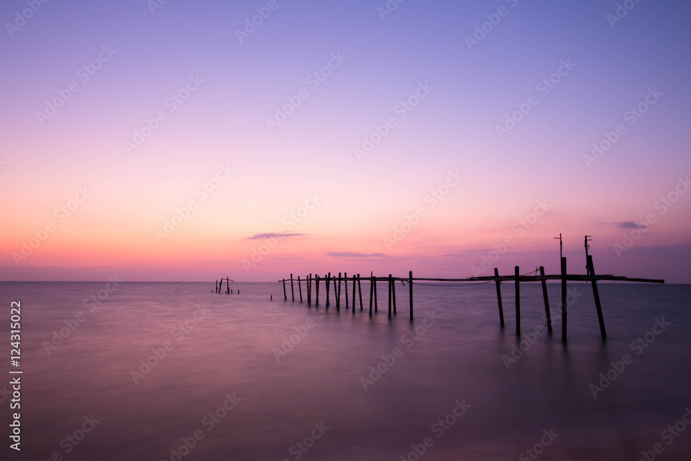 Amazing sunset beach. Long exposure bride wood and colorful suns