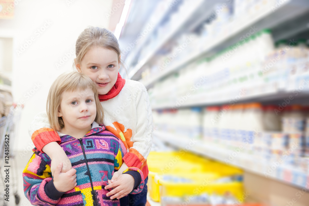 two little girls  at   grocery store.