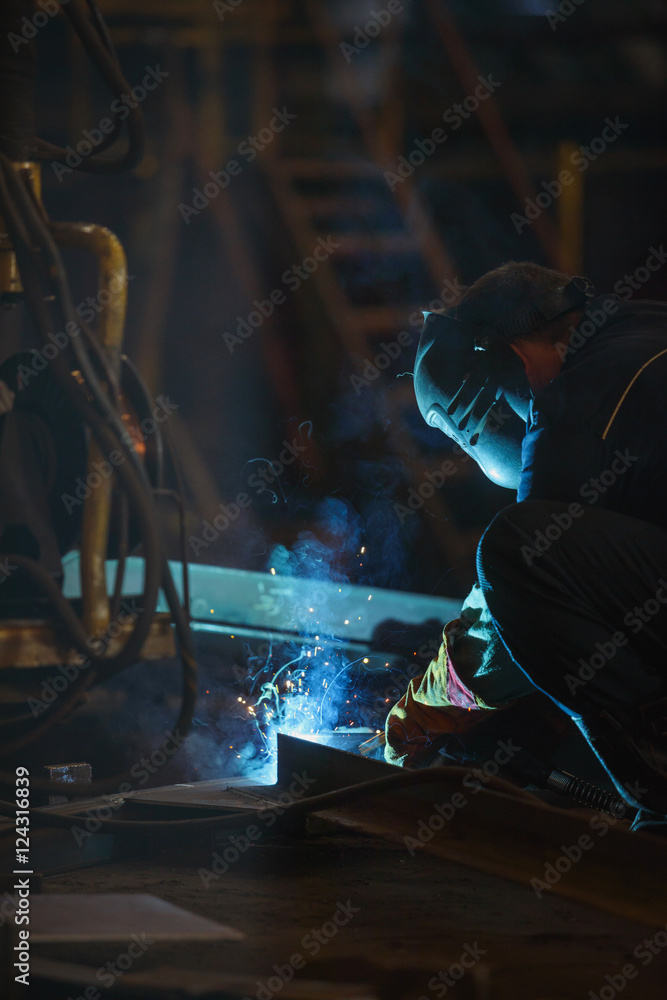 Industrial Worker at the factory welding closeup.
