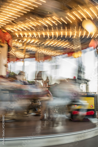 Carousel with horses in amusement park.