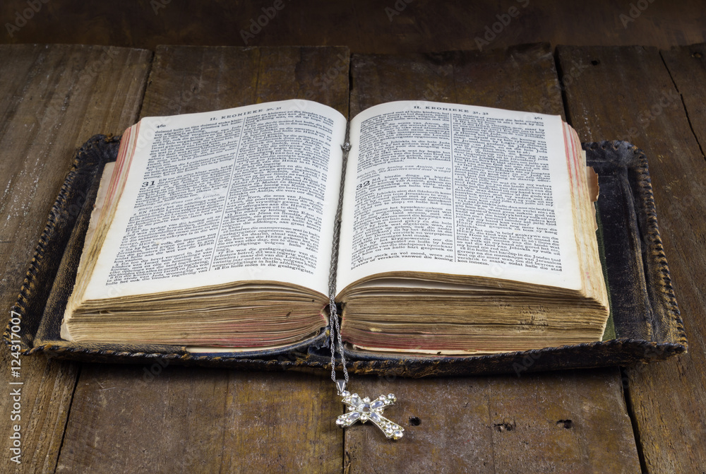 Fototapeta premium Old Holy Bible on rustic wood table with cross book mark