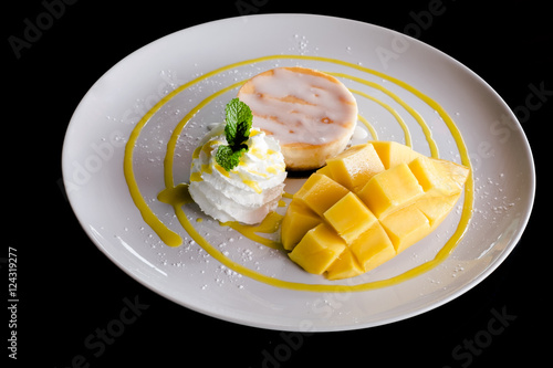 Mango and ice cream decorated with whipped cream.