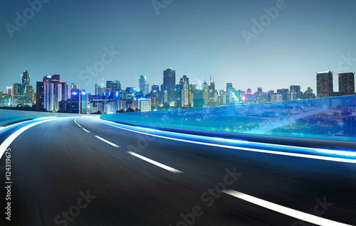 Blue neon light highway overpass motion blur with city  skyline background   night scene .