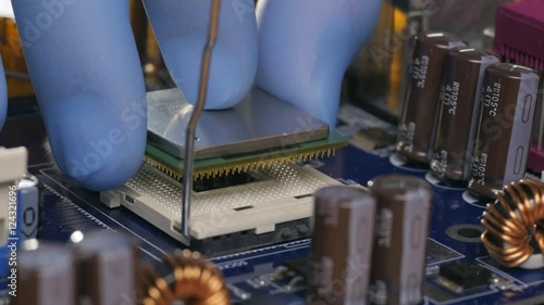 Engineer plug in CPU microprocessor to motherboard socket
