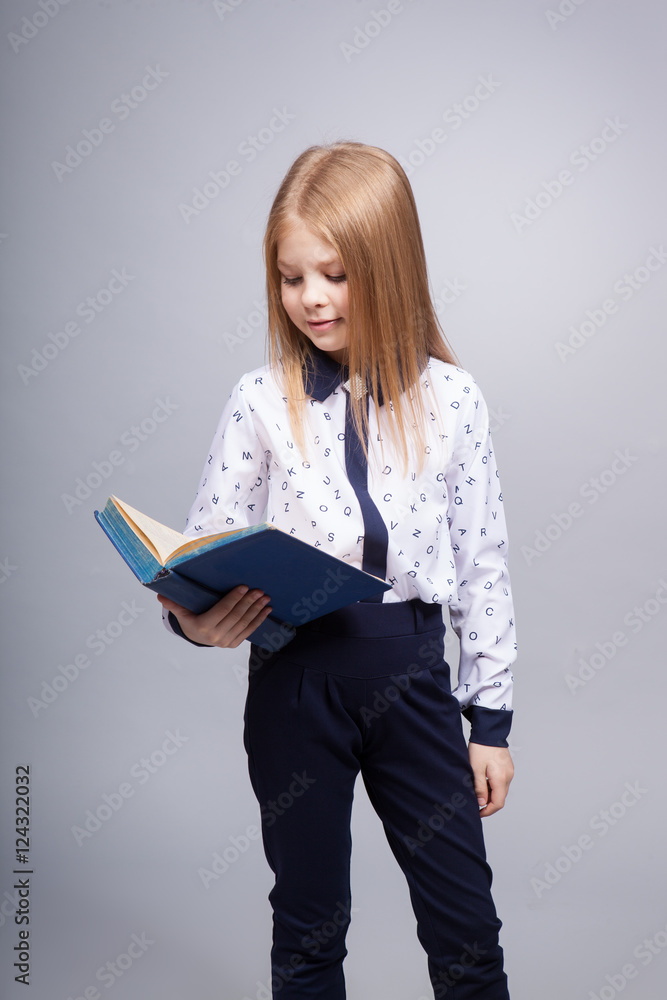Stylish girl with the book on a gray background in the studio Stylish girl with the book on a gray background in the studio