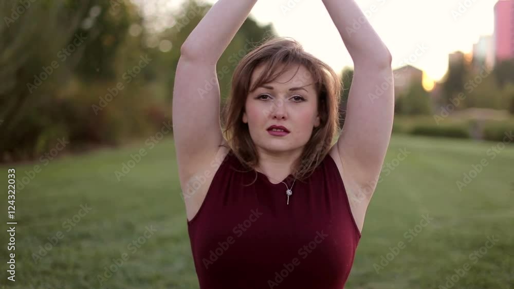 Girl with excess weight doing yoga exercise in the Park. Girl with excess weight doing yoga exercise in the Park.