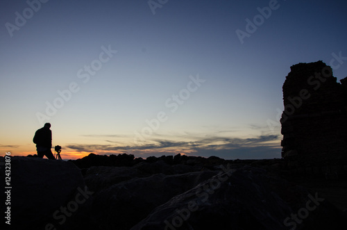 Photographer at sunset next to the ancient tower Ladispoli Rome Italy