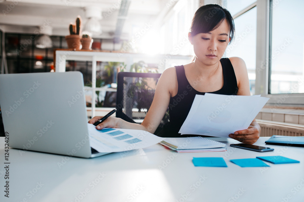 Businesswoman doing paperwork at her workplace Businesswoman doing paperwork at her workplace