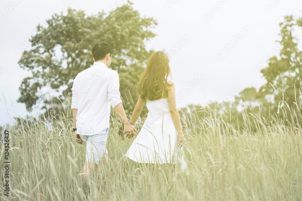 Lover hands hold together in the beautiful garden. Romantic lover theme outdoor with warm color filter added. Lover hands hold together in the beautiful garden. Romantic lover theme outdoor with warm color filter added.