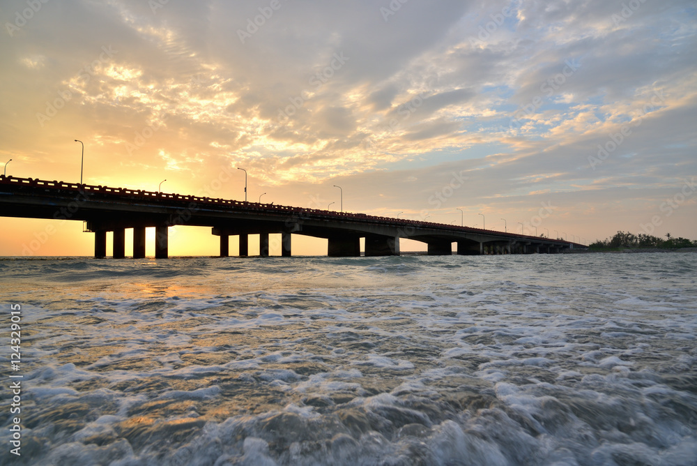 sunset bridge over a sea
