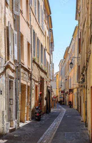 Romantic tiny street in central Aix-En-Provence, South of France on hot summer day without pedestrians