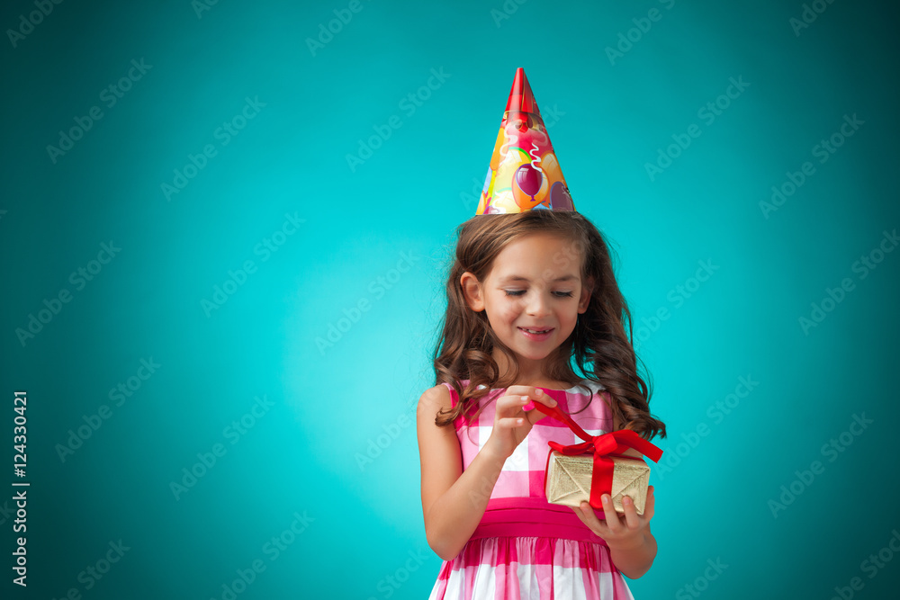 The cute cheerful little girl on blue background The cute cheerful little girl on blue background