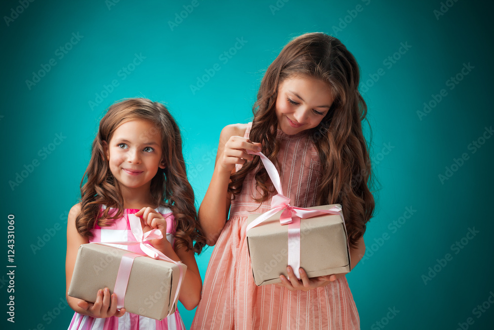 The two cute cheerful little girls on blue background The two cute cheerful little girls on blue background