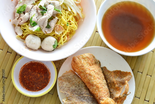 yellow noodle topping pork ball and crispy fish skin with soup