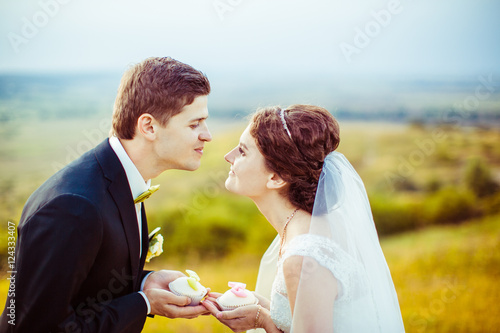 Charming wedding couple looks in each other eyes holding white c