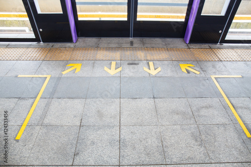 Arrow sign on floor at the sky train station