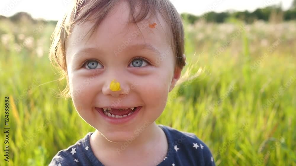 Portrait of cute little child girl playing on nature meadow with face smeared with paint Portrait of cute little child girl playing on nature meadow with face smeared with paint