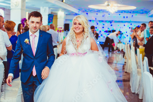 Glorious bride walks into the restaurant hall together with a gr © pyrozenko13