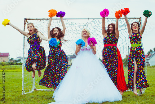 Bridesmaids and bride jump with the bright pompons before the go