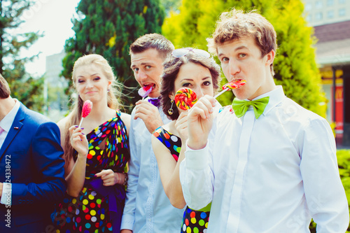 Funny groomsman holds tasty sugar candy in his mouth