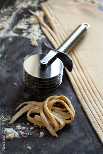 Making taglatelle with a pasta rolling cutter photo