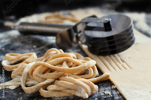 Making taglatelle with a pasta rolling cutter photo