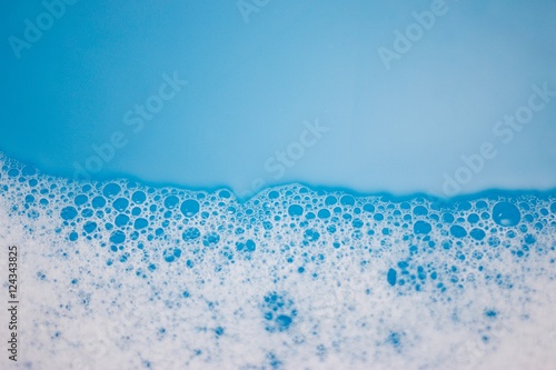 Abstract background of soap foam, suds, shower. Blue background. soft focus, macro view