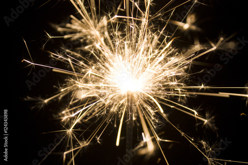 Burning sparkler isolated on black background