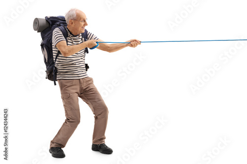 Mature hiker pulling a rope