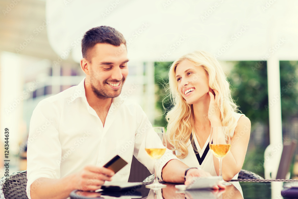 happy couple with bank card and bill at restaurant happy couple with bank card and bill at restaurant