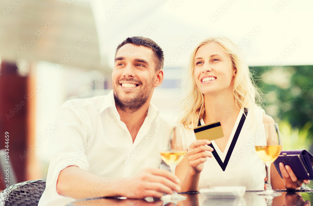 happy couple with bank card and bill at restaurant happy couple with bank card and bill at restaurant