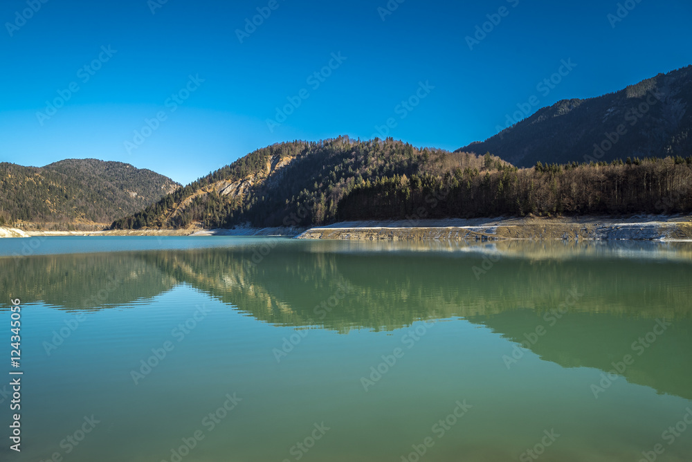 Spiegelung der winterlichen Berge im klaren Wasser des Sylvensteinsees