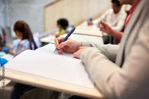 student writing to notebook at exam or lecture
