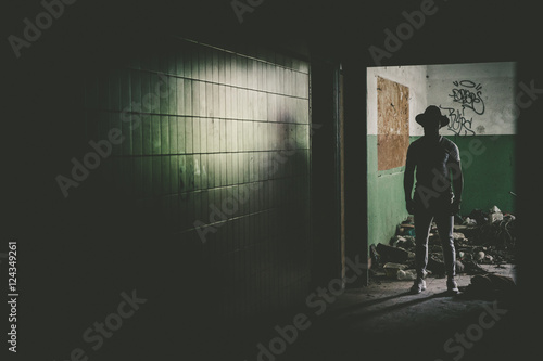 Dark figure in hat standing in door. photo