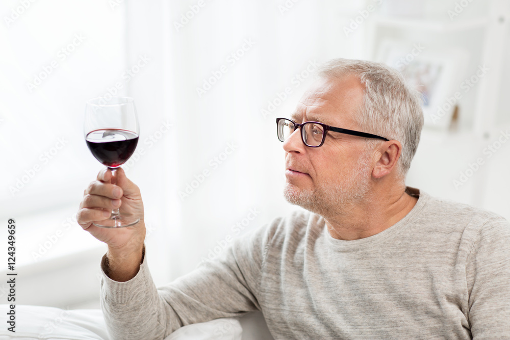 senior man drinking red wine from glass at home senior man drinking red wine from glass at home