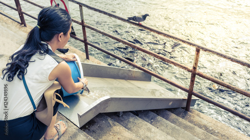 Quadro em tela Woman releasing fish to the Chao Phraya river  according to the belief of Buddhi
